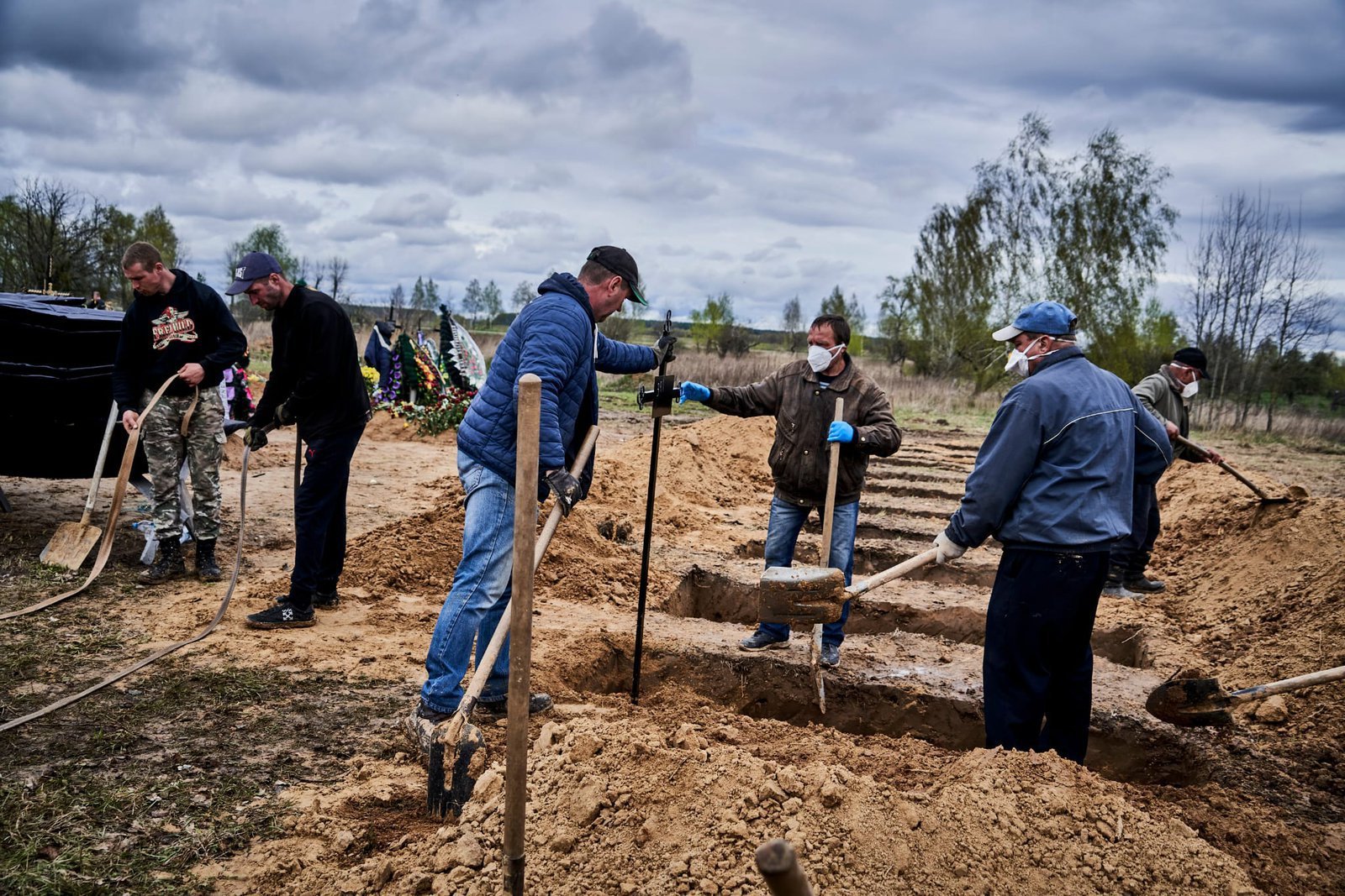 The diggers of the communal enterprise are preparing graves to bury the people who had died under the rubble in Borodyanka