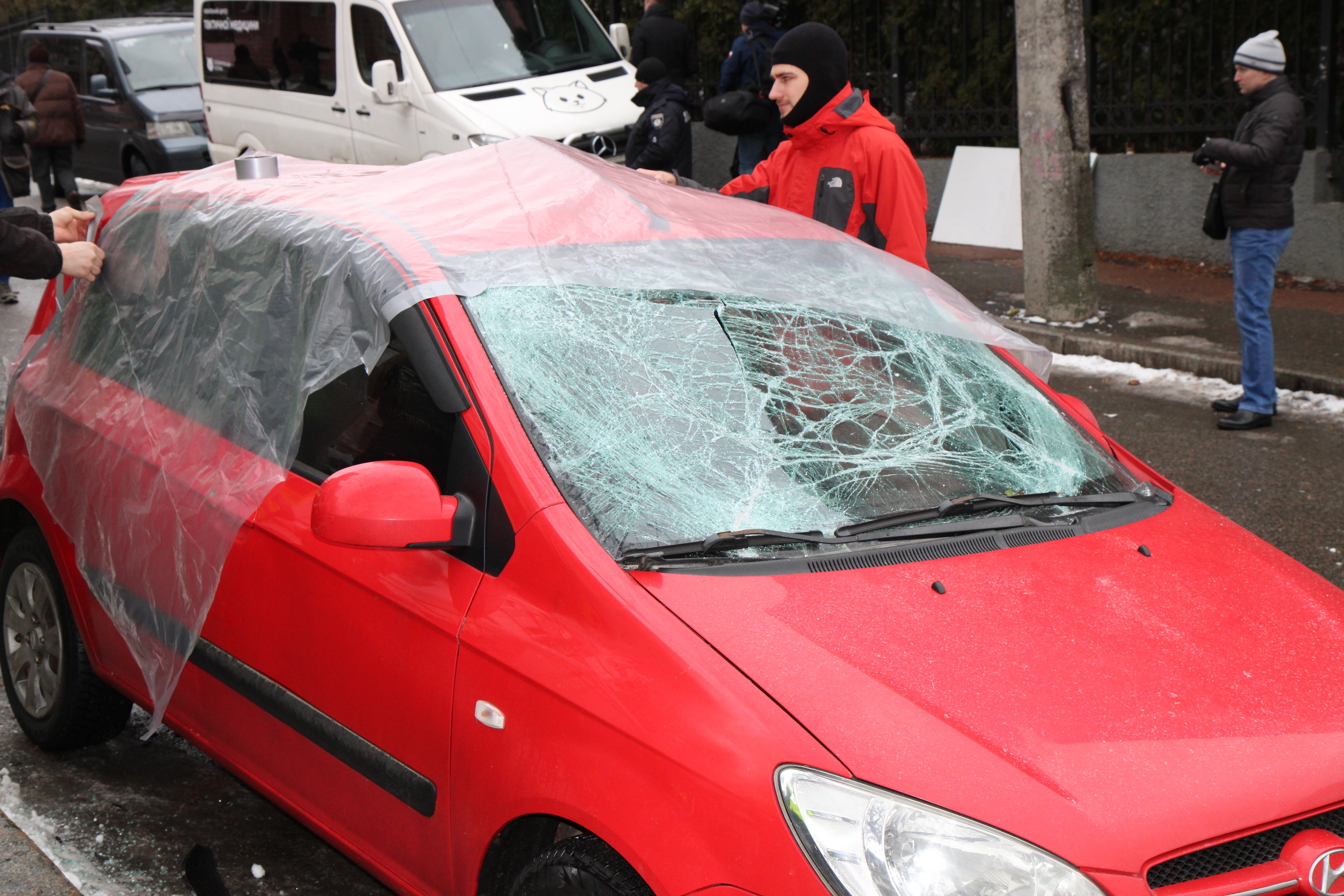 The women came in this car to go in for sports. Volunteers seal the car with plastic wrap