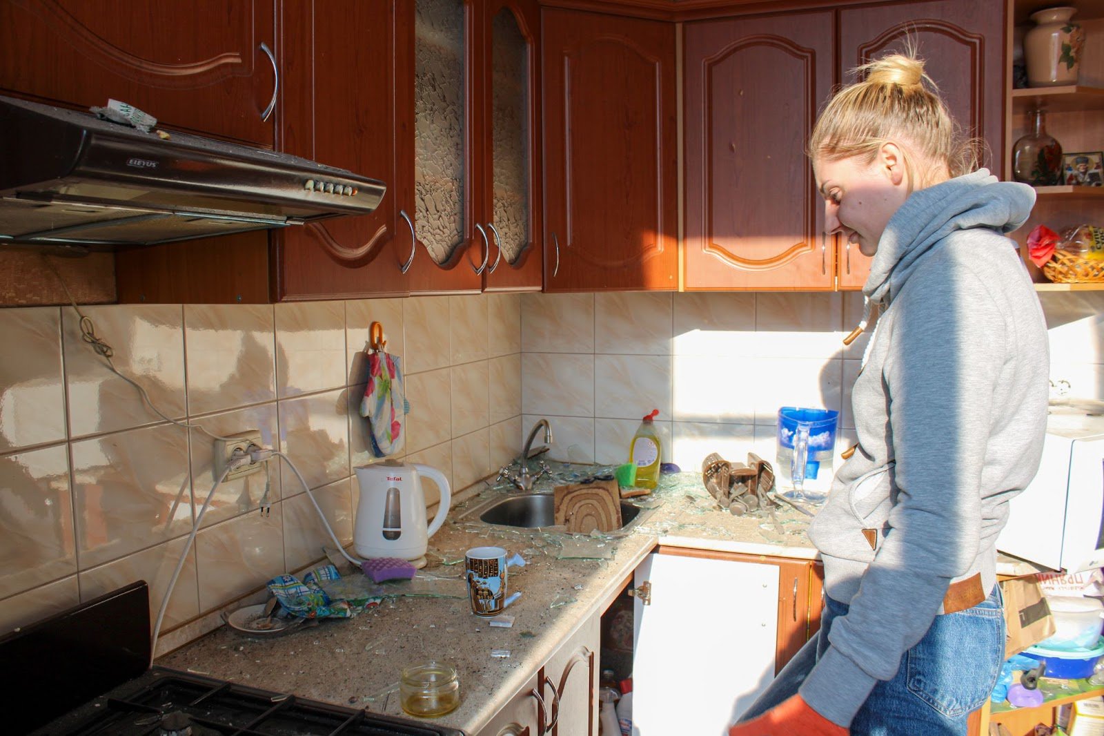 A broken cup and an unused tea bag in front of Olena in the kitchen. Author's photo