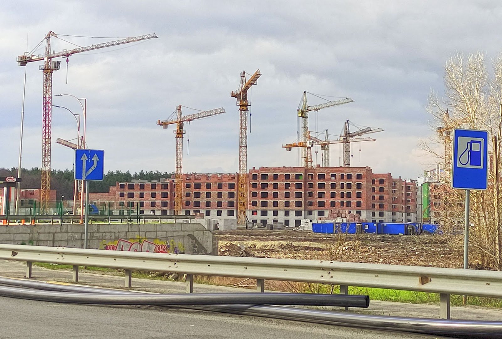 В'їзд в Ірпінь з нової траси. Новобудови, які почали зводити до окупації, постраждали найменше. На узбіччі — новий водогін, який щойно проклали до Ірпеня з Києва