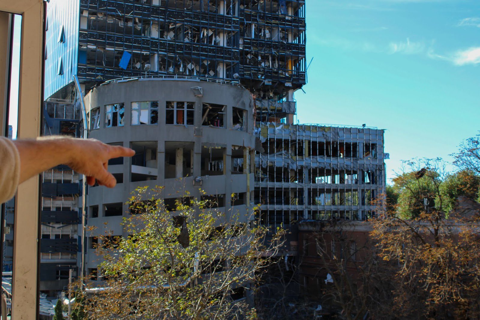 Yuriy points at the building that was hit by the rocket