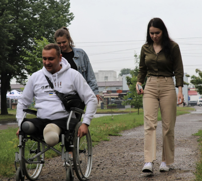 Військовослужбовець Сергій Копищик після поранення в бою рік пересувався на колісному кріслі, нині освоює протези. Заради показового експерименту він погодився проїхатися на кріслі вулицями 40-го кварталу в Луцьку. Фото: Марія Бандура.